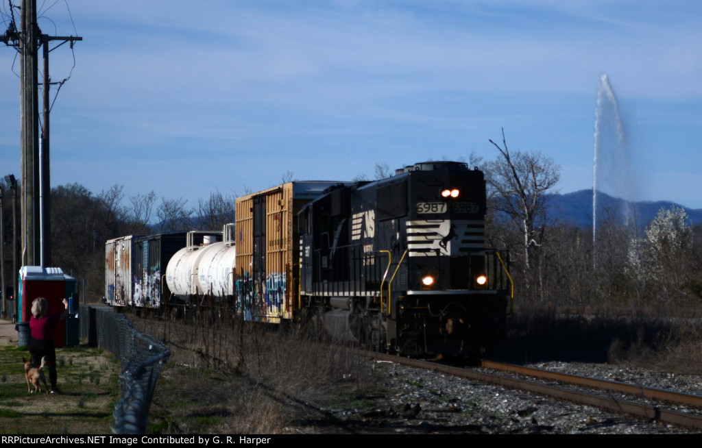 The NS yard job, E23, returns from its interchange duties with CSX with four cars this trip.  Woman and (wo)man's best friend takes a picture on the left.  The Langley Fountain sprays skyward to the right.